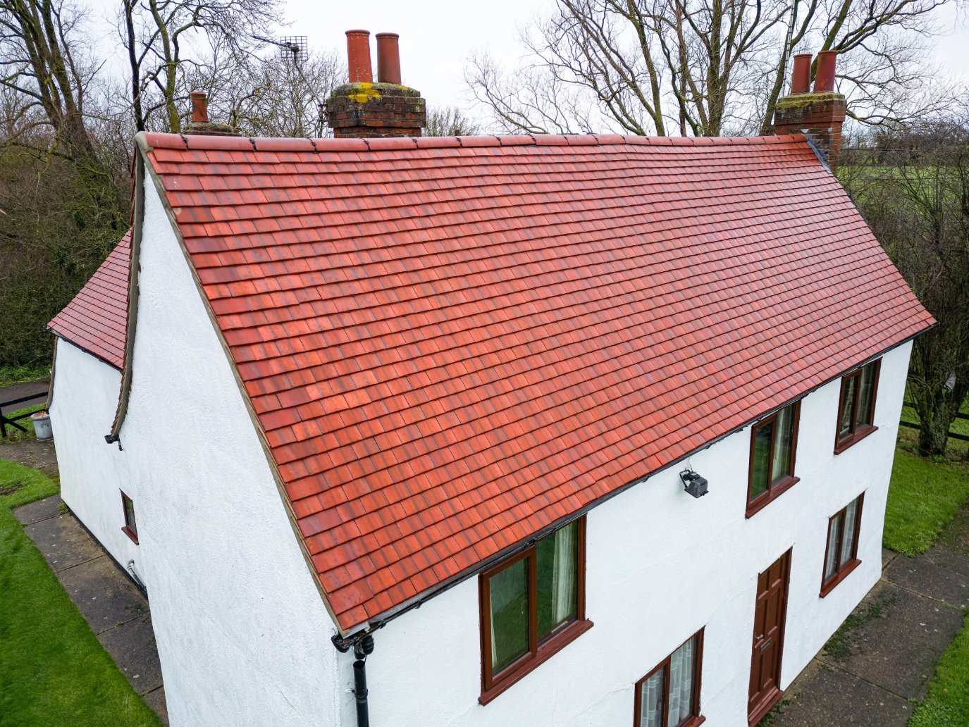 Large farmhouse after exterior cleaning with spotless walls, clean roof, and sparkling windows